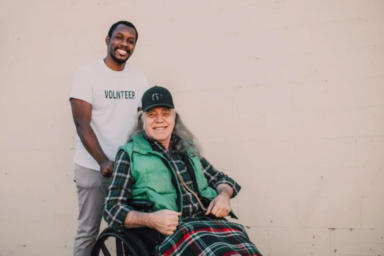 A man in a wheelchair with another man standing behind him