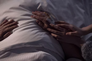 Holding hands on a hospital bed